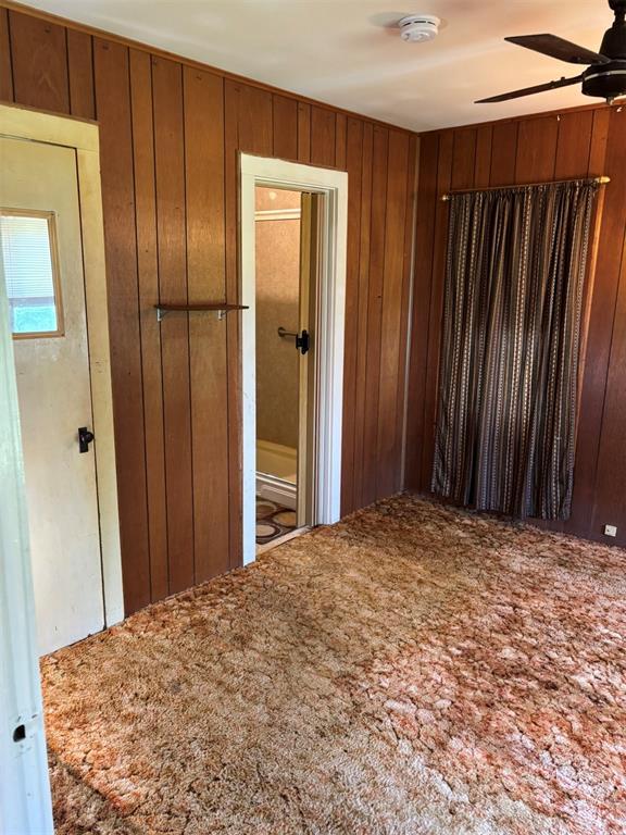 316 N Crenshaw St, Wayne, OK 73080 - spare room with carpet floors, ceiling fan, a smoke detector, and wood walls