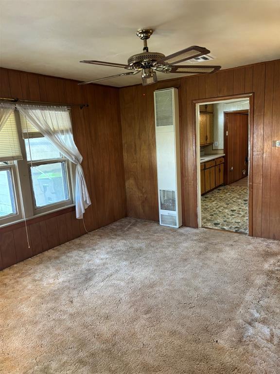 316 N Crenshaw St, Wayne, OK 73080 - carpeted spare room featuring a ceiling fan and wood walls