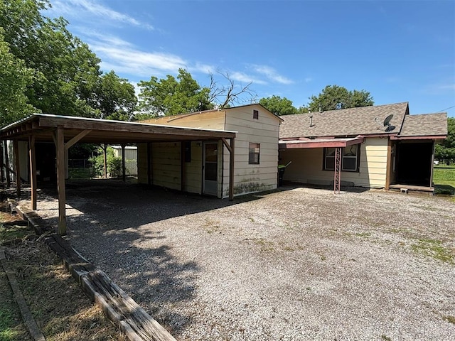 316 N Crenshaw St, Wayne, OK 73080 - view of front of house with gravel driveway, a detached carport, and a shingled roof