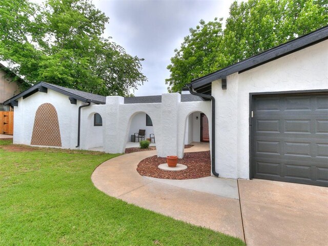 10109 Bison Cir, Yukon, OK 73099 - view of front of property with stucco siding, a front lawn, an attached garage, and concrete driveway
