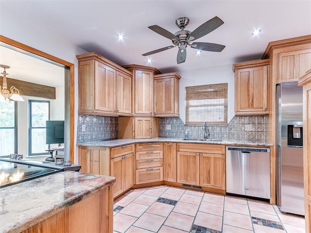 10109 Bison Cir, Yukon, OK 73099 - kitchen with appliances with stainless steel finishes, a sink, decorative backsplash, a ceiling fan, and light stone countertops