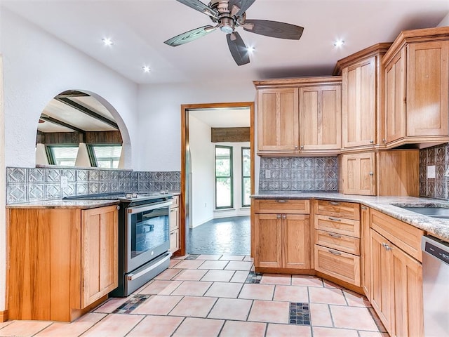 10109 Bison Cir, Yukon, OK 73099 - kitchen with stainless steel appliances, tasteful backsplash, light stone counters, a ceiling fan, and a sink