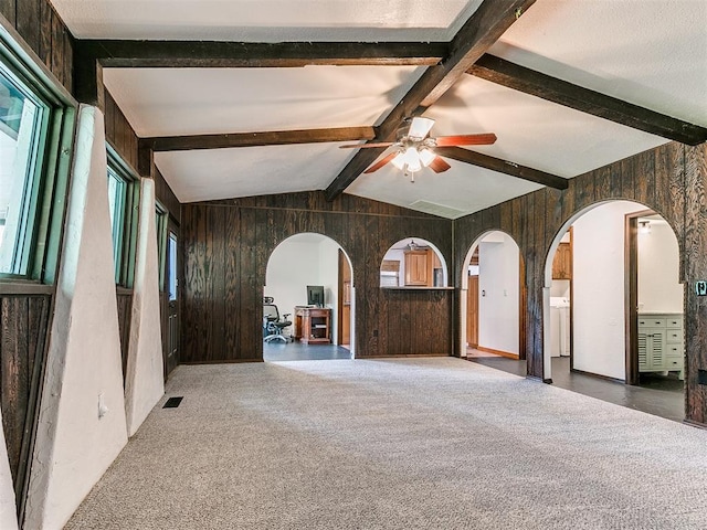10109 Bison Cir, Yukon, OK 73099 - carpeted spare room featuring arched walkways, wood walls, and a ceiling fan