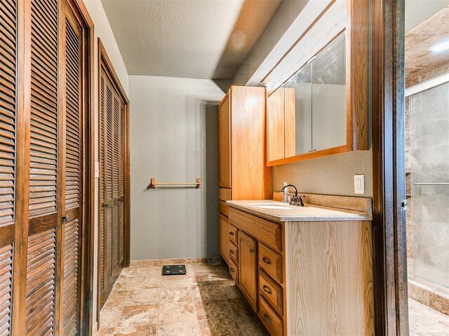 10109 Bison Cir, Yukon, OK 73099 - bathroom featuring a closet, vanity, and stone finish floors