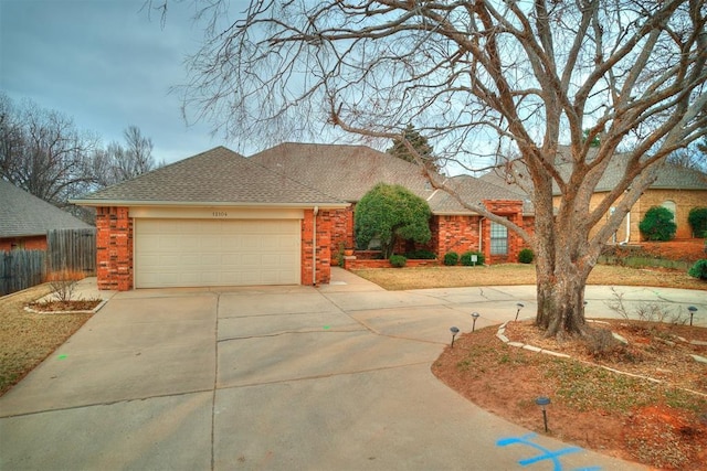 12104 Cantle Rd, Oklahoma City, OK 73120 - view of front facade with driveway, an attached garage, roof with shingles, and brick siding