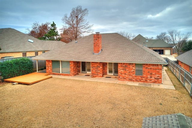 12104 Cantle Rd, Oklahoma City, OK 73120 - back of house with a chimney, a fenced backyard, a wooden deck, and brick siding