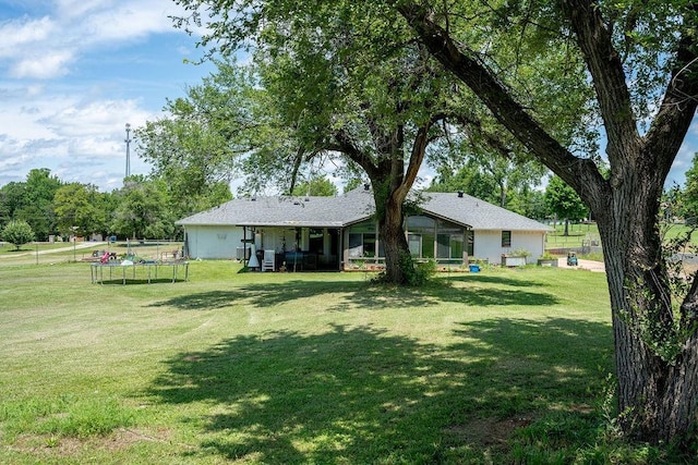 11110 Jeffords Ave, Choctaw, OK 73020 - rear view of property featuring a trampoline, a yard, and a sunroom