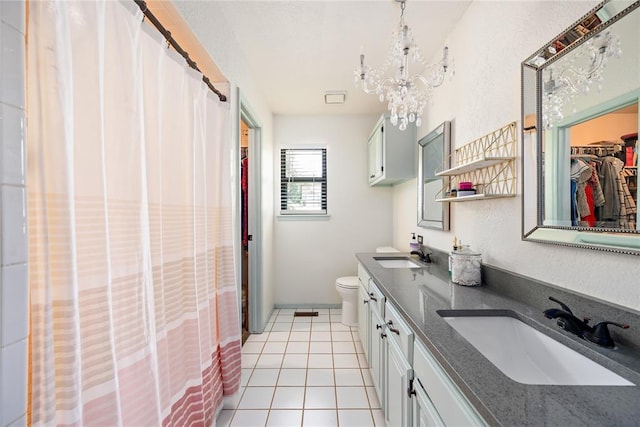 11110 Jeffords Ave, Choctaw, OK 73020 - bathroom featuring double vanity, a chandelier, toilet, tile patterned floors, and a spacious closet