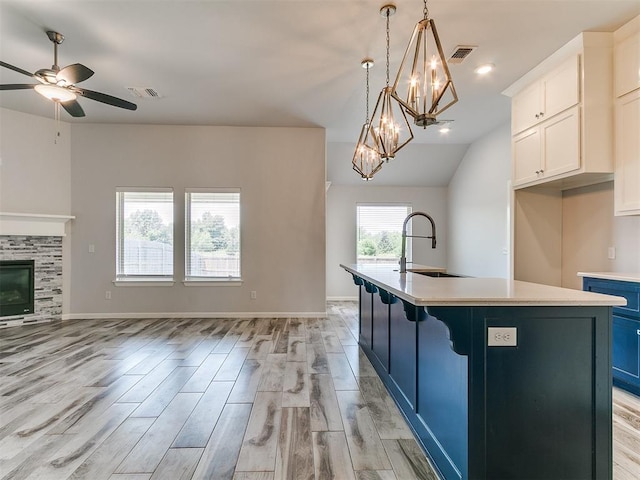 3909 Palisade Ln, Oklahoma City, OK 73179 - kitchen with a sink, open floor plan, white cabinetry, a center island with sink, and light countertops