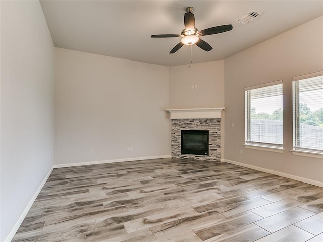 3909 Palisade Ln, Oklahoma City, OK 73179 - unfurnished living room featuring wood finished floors, a ceiling fan, a stone fireplace, and baseboards