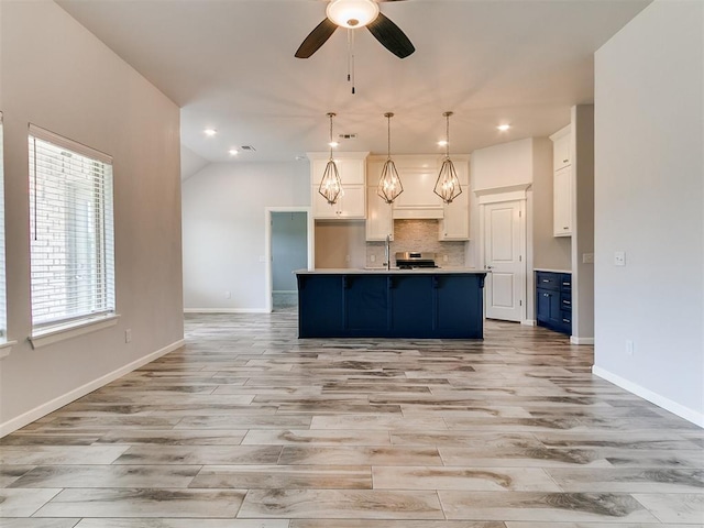 3909 Palisade Ln, Oklahoma City, OK 73179 - kitchen featuring blue cabinets, ceiling fan, light wood finished floors, decorative backsplash, and light countertops