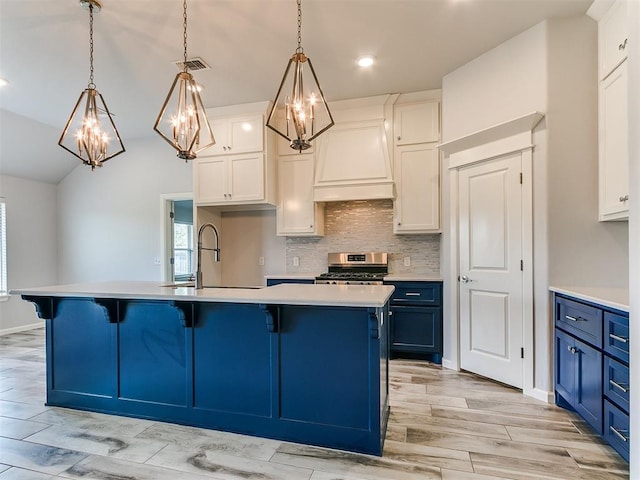 3909 Palisade Ln, Oklahoma City, OK 73179 - kitchen featuring blue cabinetry, premium range hood, stainless steel stove, a sink, and light countertops