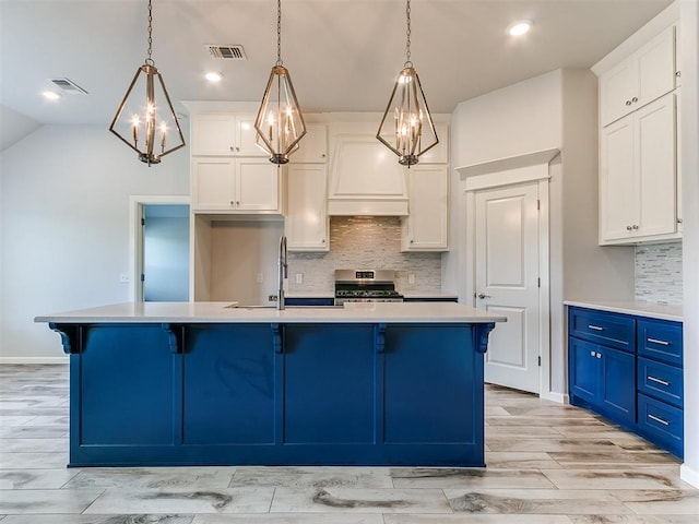 3909 Palisade Ln, Oklahoma City, OK 73179 - kitchen with stainless steel range oven, blue cabinets, a sink, light countertops, and decorative backsplash