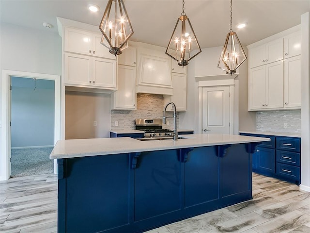 3909 Palisade Ln, Oklahoma City, OK 73179 - kitchen with a chandelier, blue cabinets, light countertops, light wood-type flooring, and recessed lighting