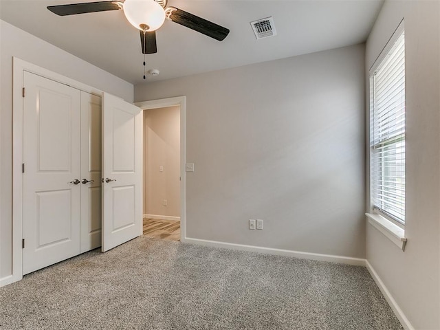 3909 Palisade Ln, Oklahoma City, OK 73179 - unfurnished bedroom with light colored carpet, baseboards, ceiling fan, and a closet