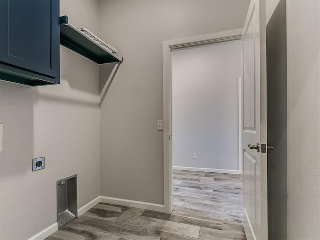 3909 Palisade Ln, Oklahoma City, OK 73179 - washroom featuring electric dryer hookup, cabinet space, light wood-type flooring, and baseboards