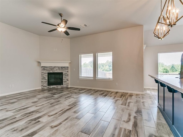 3909 Palisade Ln, Oklahoma City, OK 73179 - unfurnished living room with plenty of natural light, light wood-type flooring, a chandelier, and ceiling fan