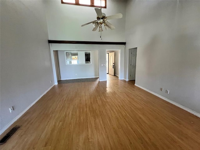 74 Fox Run Cir, Jenks, OK 74037 - unfurnished living room featuring a high ceiling, baseboards, wood finished floors, and ceiling fan