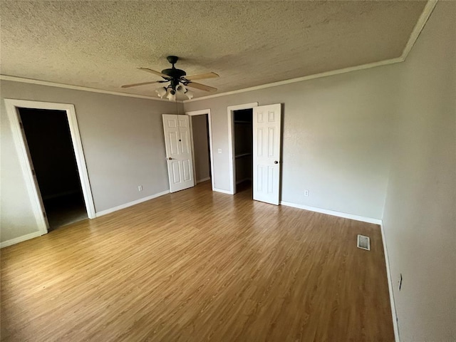 74 Fox Run Cir, Jenks, OK 74037 - unfurnished bedroom with a textured ceiling, crown molding, wood finished floors, baseboards, and ceiling fan