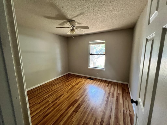 74 Fox Run Cir, Jenks, OK 74037 - unfurnished room featuring baseboards, wood finished floors, ceiling fan, and a textured ceiling