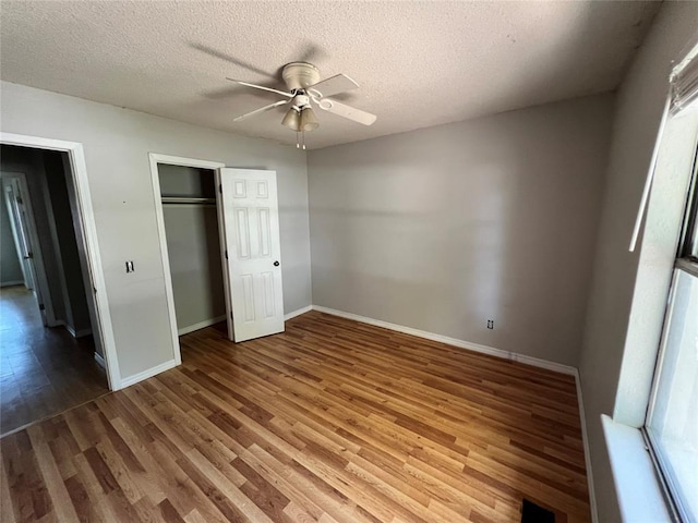 74 Fox Run Cir, Jenks, OK 74037 - unfurnished bedroom featuring wood finished floors, baseboards, a textured ceiling, a closet, and ceiling fan