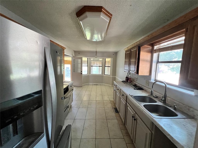 74 Fox Run Cir, Jenks, OK 74037 - kitchen with stainless steel fridge with ice dispenser, a sink, light countertops, a textured ceiling, and light tile patterned floors