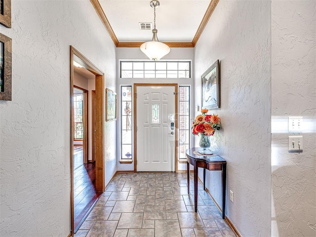 7705 Dripping Springs Ln, Oklahoma City, OK 73150 - foyer entrance featuring a textured wall, stone tile flooring, and ornamental molding