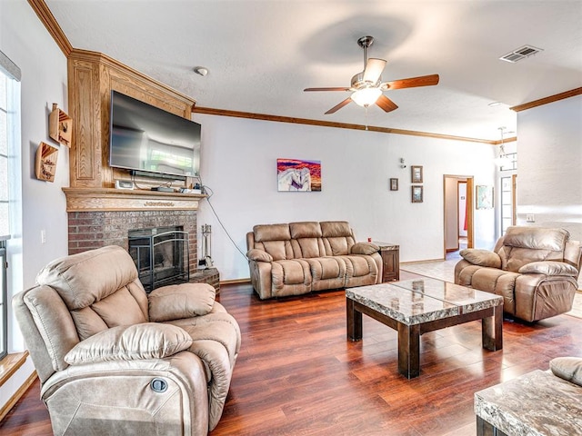 7705 Dripping Springs Ln, Oklahoma City, OK 73150 - living room with ornamental molding, a ceiling fan, wood finished floors, and a brick fireplace