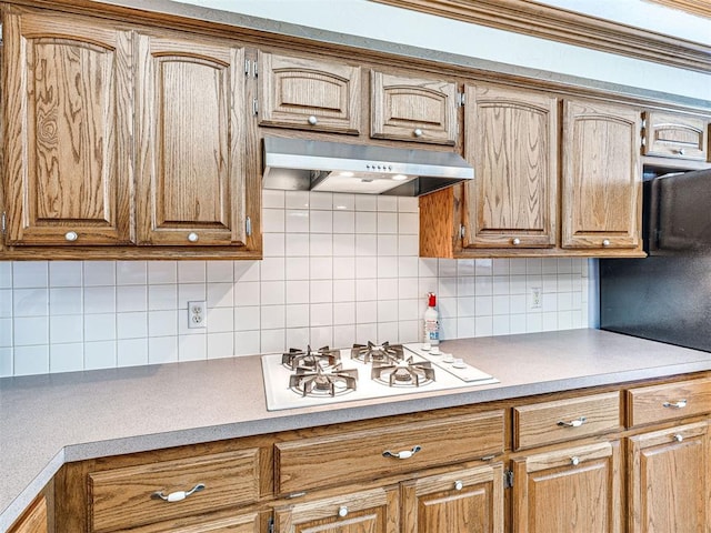 7705 Dripping Springs Ln, Oklahoma City, OK 73150 - kitchen featuring under cabinet range hood, white gas cooktop, light countertops, and tasteful backsplash