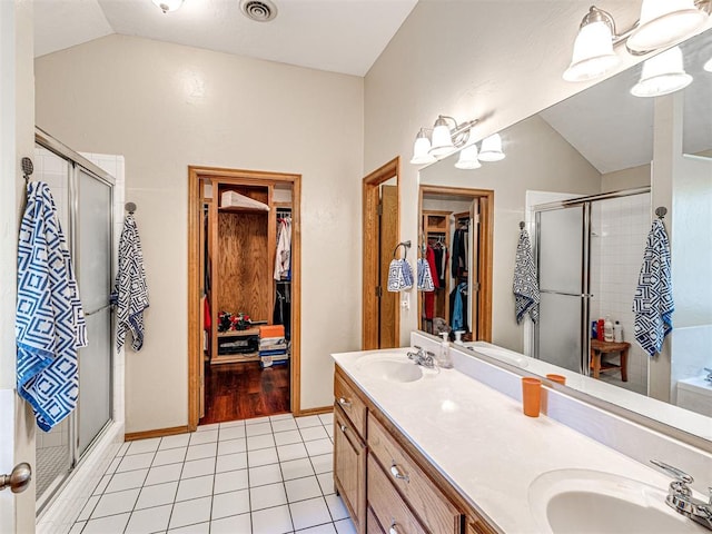 7705 Dripping Springs Ln, Oklahoma City, OK 73150 - full bathroom featuring lofted ceiling, double vanity, a shower stall, tile patterned flooring, and a spacious closet