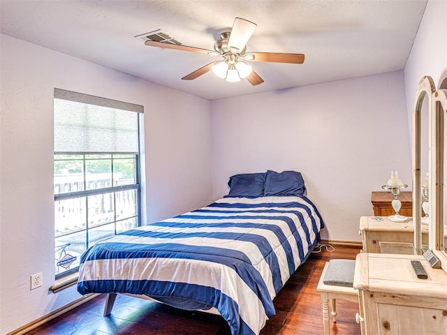 7705 Dripping Springs Ln, Oklahoma City, OK 73150 - bedroom with dark wood-style floors and a ceiling fan