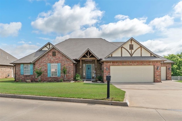 2528 E Bradley St, Shawnee, OK 74804 - tudor home featuring an attached garage, driveway, a front yard, and brick siding
