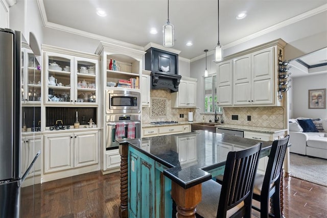 2528 E Bradley St, Shawnee, OK 74804 - kitchen featuring appliances with stainless steel finishes, dark wood-style floors, a kitchen bar, crown molding, and pendant lighting