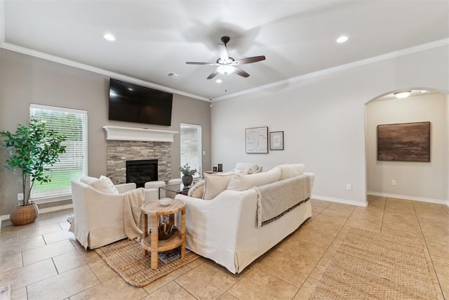 4932 Mahogany Dr, Edmond, OK 73025 - living area with arched walkways, a ceiling fan, crown molding, a fireplace, and light tile patterned flooring