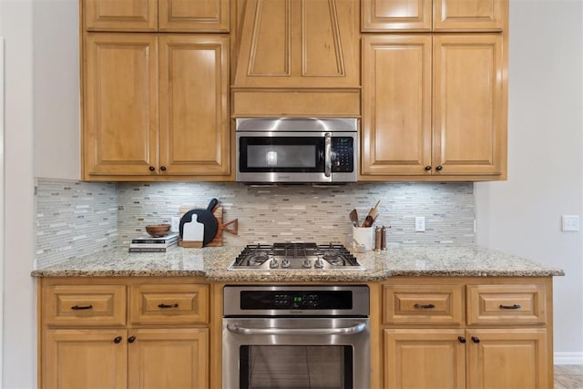4932 Mahogany Dr, Edmond, OK 73025 - kitchen featuring appliances with stainless steel finishes, tasteful backsplash, and light stone counters
