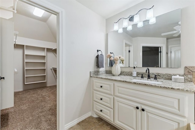 4932 Mahogany Dr, Edmond, OK 73025 - bathroom featuring vanity, ceiling fan, a walk in closet, and baseboards
