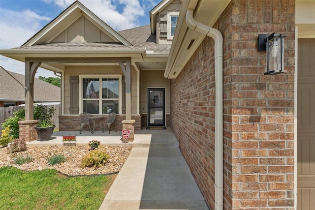 4932 Mahogany Dr, Edmond, OK 73025 - doorway to property featuring brick siding, a shingled roof, and a porch