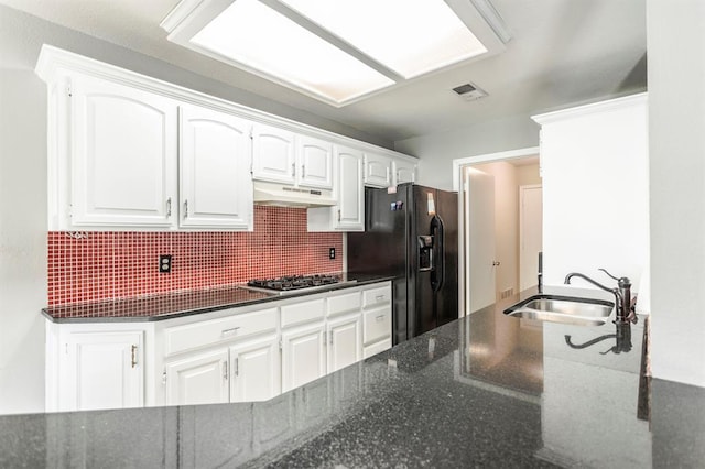 3305 Outpost Cir, Norman, OK 73072 - kitchen featuring a sink, under cabinet range hood, white cabinetry, backsplash, and black refrigerator with ice dispenser