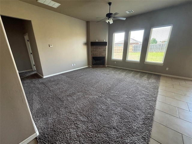 11232 NW 101st St, Yukon, OK 73099 - unfurnished living room with a ceiling fan, baseboards, a brick fireplace, and carpet floors