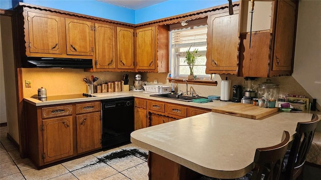 4001 N Bryan Ave, Shawnee, OK 74804 - kitchen with under cabinet range hood, black appliances, a peninsula, a sink, and brown cabinets