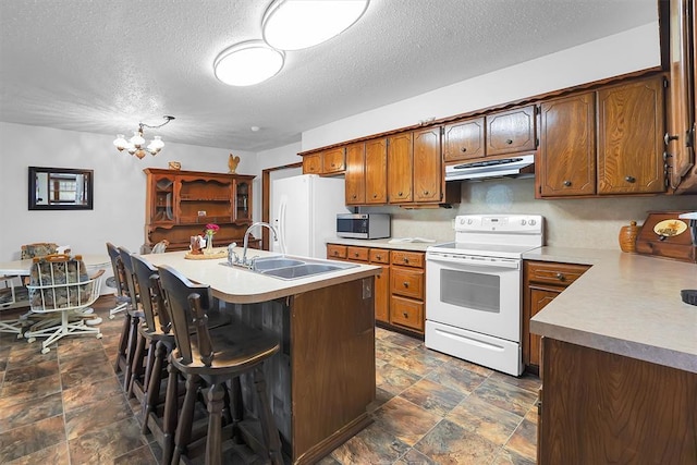 409 S Mcdonald St, Dill City, OK 73641 - kitchen featuring white appliances, under cabinet range hood, a sink, stone finish floors, and a textured ceiling