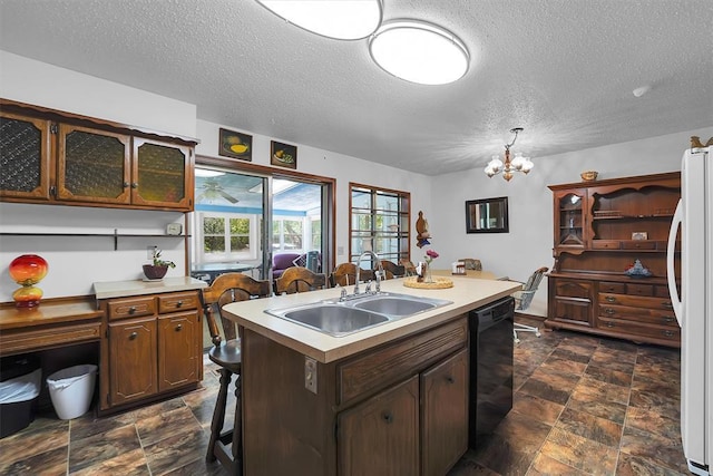 409 S Mcdonald St, Dill City, OK 73641 - kitchen featuring a sink, freestanding refrigerator, stone finish floors, black dishwasher, and a kitchen island with sink