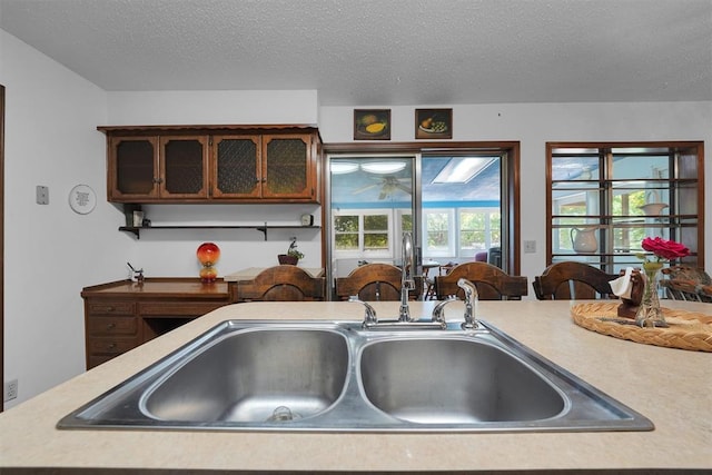 409 S Mcdonald St, Dill City, OK 73641 - kitchen with light countertops, a sink, and a textured ceiling