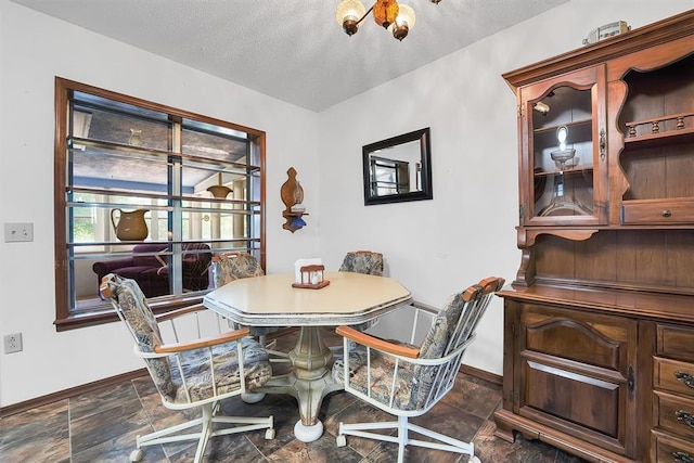 409 S Mcdonald St, Dill City, OK 73641 - dining area featuring baseboards, dark stone finish flooring, and a textured ceiling
