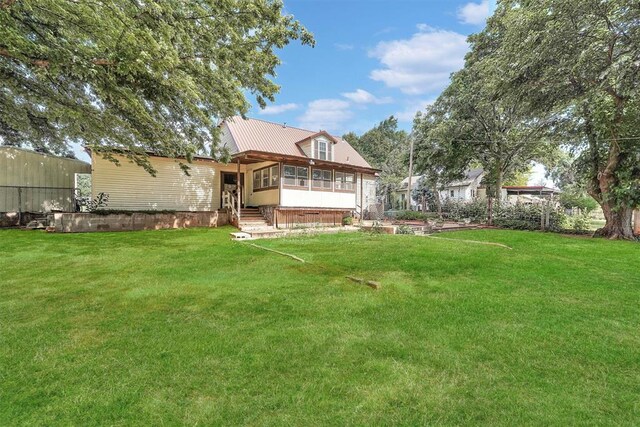 409 S Mcdonald St, Dill City, OK 73641 - back of house with a yard, metal roof, a sunroom, and entry steps