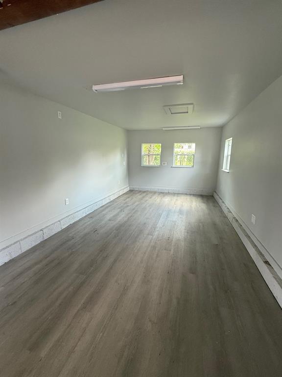 1707 N Louisa Ave, Shawnee, OK 74804 - spare room with wood finished floors, plenty of natural light, and baseboards