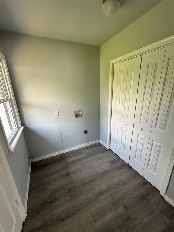 1707 N Louisa Ave, Shawnee, OK 74804 - unfurnished bedroom with dark wood-style floors, a closet, and baseboards
