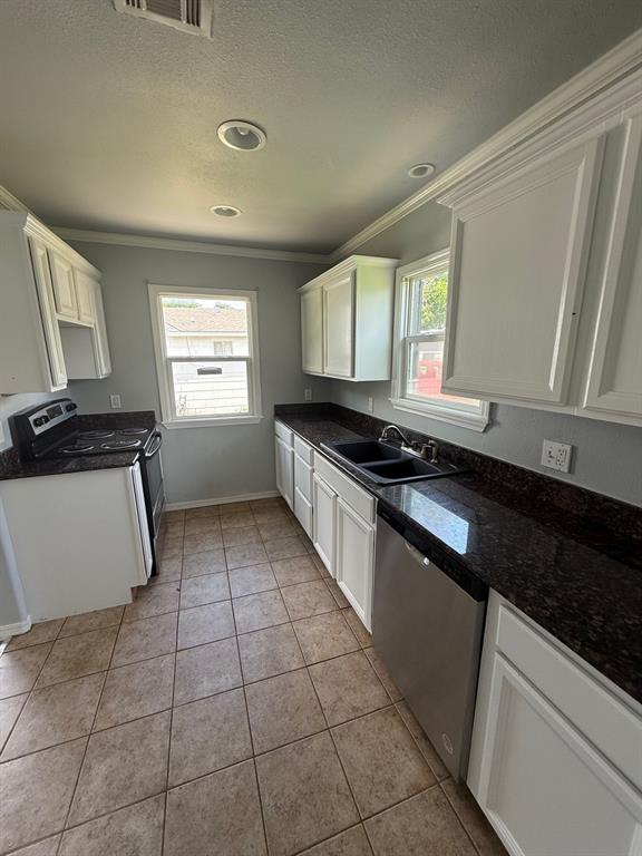 1707 N Louisa Ave, Shawnee, OK 74804 - kitchen featuring stainless steel appliances, crown molding, a sink, dark countertops, and healthy amount of natural light