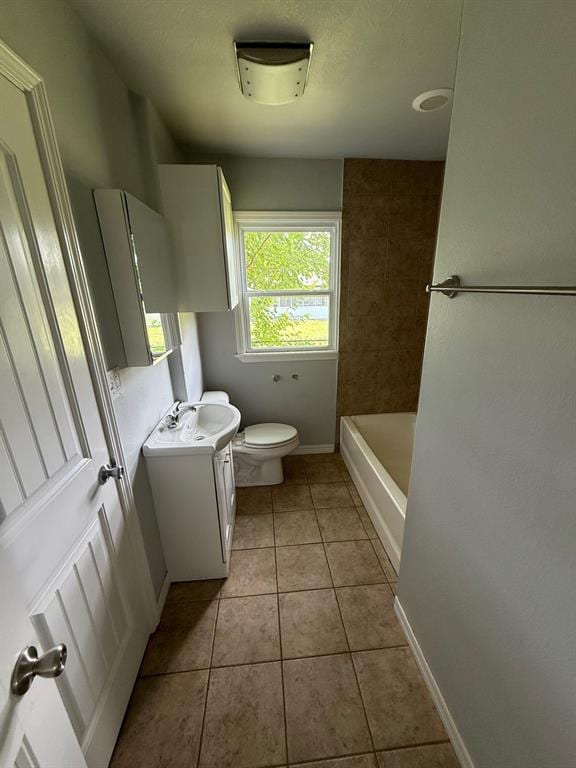 1707 N Louisa Ave, Shawnee, OK 74804 - bathroom featuring vanity, toilet, tile patterned floors, a bathtub, and baseboards