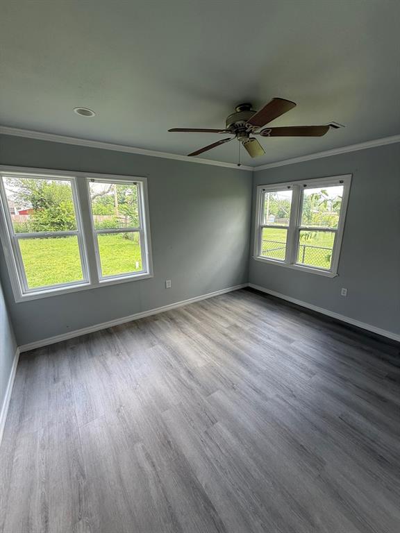 1707 N Louisa Ave, Shawnee, OK 74804 - empty room with ornamental molding, baseboards, ceiling fan, and wood finished floors
